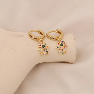Detail of golden Hamsa Hand earrings with colorful micro-set cubic zirconia on a stand