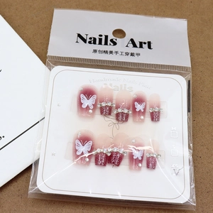 Handmade cherry gradient press-on nails with white butterfly patterns and rhinestones