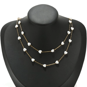 Detail of 18K gold-plated double-layer necklace with white heart pearls on black bust