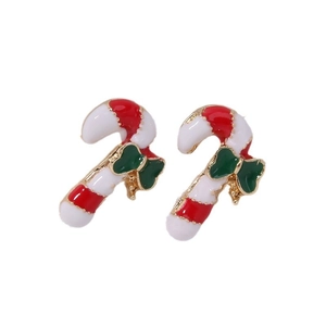 Macro detail of Christmas candy cane earrings with red white stripes and green bow