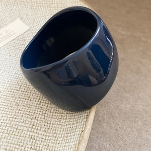 Detail view of a glossy dark blue asymmetrical wide resin ring with a sculptural design
