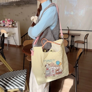 Close-up of quilted cream tote bag with puppy print and pink shoulder strap detail