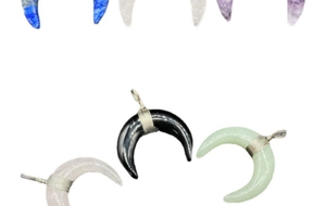 Macro detail of various crescent stone pendants with silver wire wrapped craftsmanship