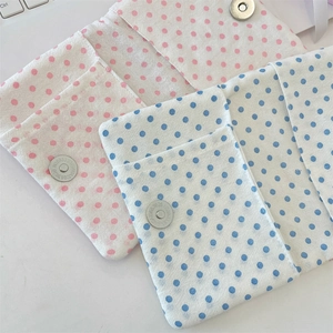 Close-up of fabric passport holder with polka dot pattern and metal magnetic snap closure