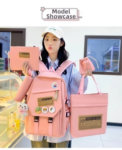 Pink nylon 5-piece student backpack set with plush bear charm and badges shown in use