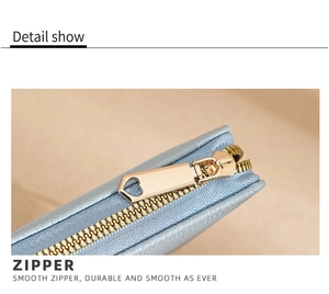 Detail of blue leather purse featuring a smooth golden heart-shaped zipper slider