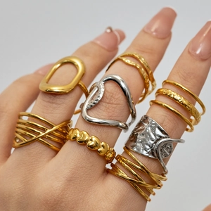 Stacked gold and silver rings set featuring heart patterns and textured metallic finishes