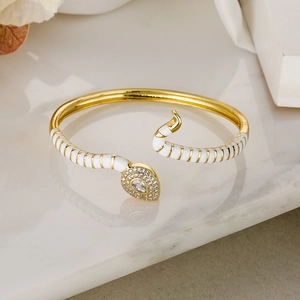 Detail of snake-shaped gold bracelet with white enamel stripes and micro-set cubic zirconia