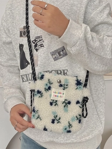 White sherpa small crossbody bag with blue floral patterns and adjustable woven strap