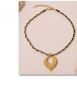 Detail of gold-plated woven leather chain necklace with leaf heart pendant and lobster clasp