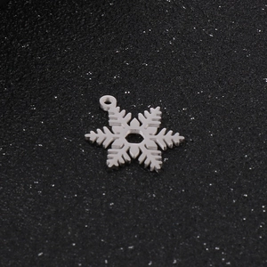 Gros plan détaillé d'un pendentif flocon de neige en acier inoxydable argenté au design classique