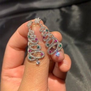 Close-up of silver Christmas tree tassel earrings with multi-colored cubic zirconia stones