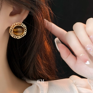 Retro vintage tiger eye stud earrings with golden hollow frame worn by a model