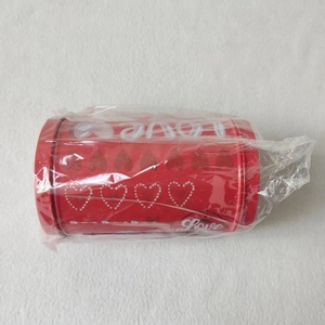 Macro shot of red tin mailbox gift box with white love patterns and heart details