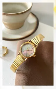 Detail of GEDI golden women's watch featuring a round iridescent pearl dial on a soft cushion