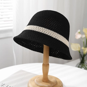 Close-up of a breathable mesh sun hat with contrasting beige woven band on a wooden stand