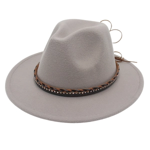 Dettaglio di cappello fedora in feltro grigio con fascia in pelle intrecciata e strass