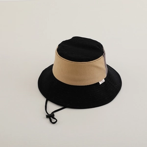 Detail of color-block bucket hat with adjustable chin strap and woven side label