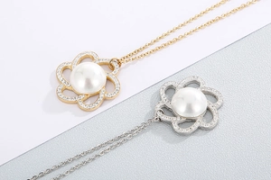 Detailed view of flower pendants with pearls and rhinestones in gold and silver finish