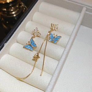 Détails des boucles d'oreilles papillon dorées avec émail bleu et cristaux scintillants