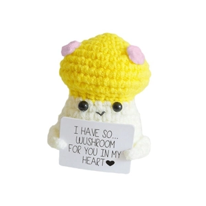 Handmade crochet mushroom doll with polka dots holding a positive heart card