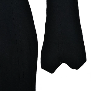 Detailed macro view of the black knitted fabric texture and premium stitching on the hem