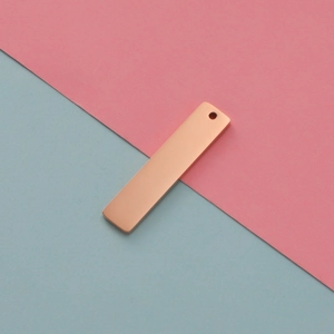 Macro shot of rectangular rose gold stainless steel pendant tag with mirror finish