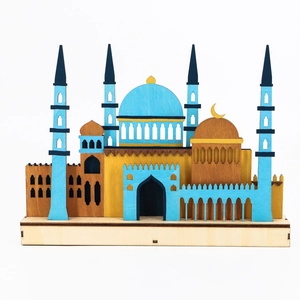 Detail of laser-cut wooden mosque model with blue dome and golden crescent for festivals