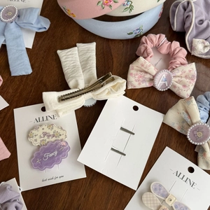 Floral embroidery headband and bow hair clips with pearls on a wooden desk background