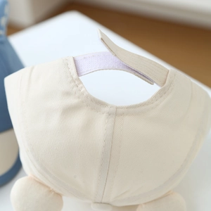 Detail of adjustable hook-and-loop strap on beige cotton baby baseball cap