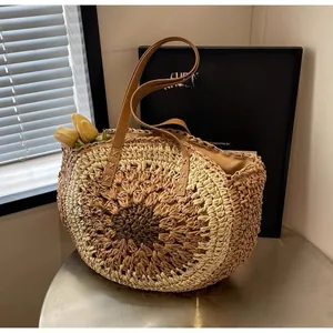 Close-up of woven paper rope beach bag featuring gradient concentric circles and leather handles
