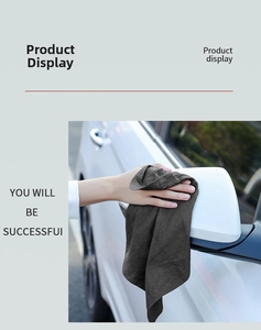 Detail of grey microfiber cloth wiping white car exterior paint for scratch-free cleaning