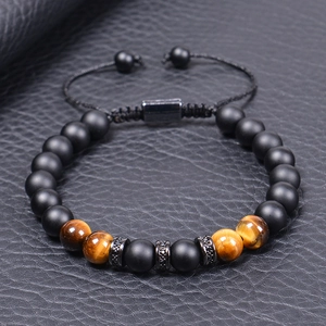 Tiger eye and matte bead bracelet with zircon accents on black leather background