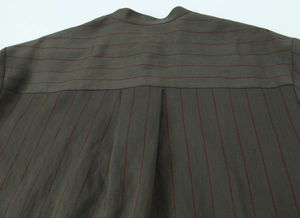Detail of olive green striped shirt showing back yoke construction and box pleat design