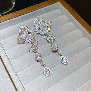 Detailed macro view of zircon flower tassel earrings on a premium velvet jewelry tray