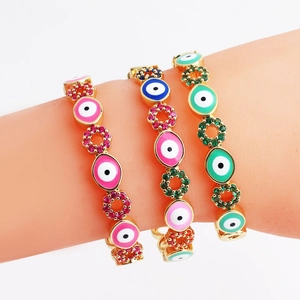 Macro detail of gold evil eye bracelets with colorful enamel and inlaid cubic zirconia