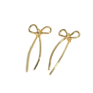 Elegant gold bow earrings with zircon and tassels shown from a side angle on white background