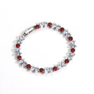 Detail of silver zircon bracelet with round red and marquise clear gemstones