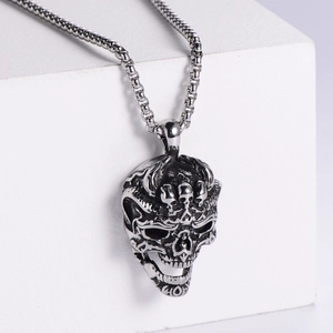 Macro detail of gothic skull pendant in vintage silver finish with a fine link chain