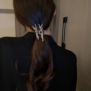 Silver liquid metal butterfly hair claw clip worn on hair with lava style design