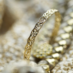 Macro view of detailed hollow floral pattern on a 925 silver vintage gold-plated bangle