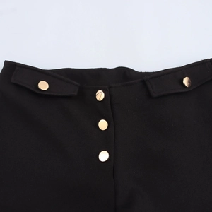 Women's black low-waist hot shorts with decorative gold metal buttons and flap waist detail