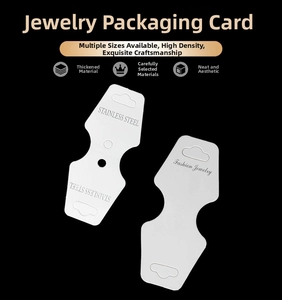 Gros plan de cartes blanches pour colliers en acier inoxydable sur fond noir profond