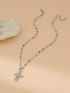 Detail of silver chain necklace with multi-colored beads and rhinestone cross pendant