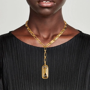 Goldene grobe Gliederkette mit rechteckigem zweifarbigem Anhänger an weiblichem Model