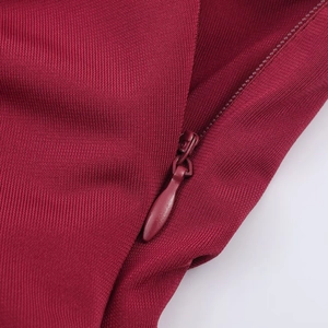 Detailed macro view of the invisible zipper and fine knit texture on a wine red dress