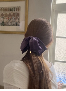 Detailansicht einer eleganten lila Samtschleife-Haarklammer in einer Halb-Hochsteckfrisur