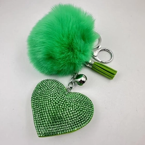 Detail view of green faux fur pompom heart rhinestone keychain with silver lobster clasp