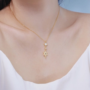 Close-up of S925 silver star pendant with white opal inlay and zircon stones on a gold chain
