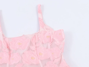 Détail de robe rose en tulle jacquard avec broderies de roses et cœurs dorés